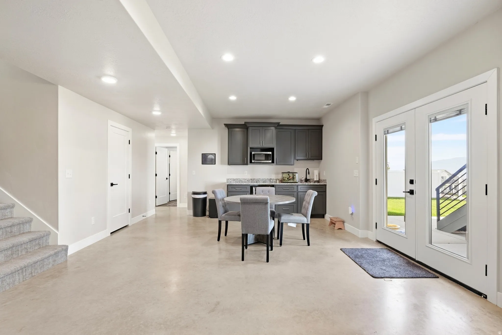 Spacious open concept living area with light-toned flooring and recessed lighting