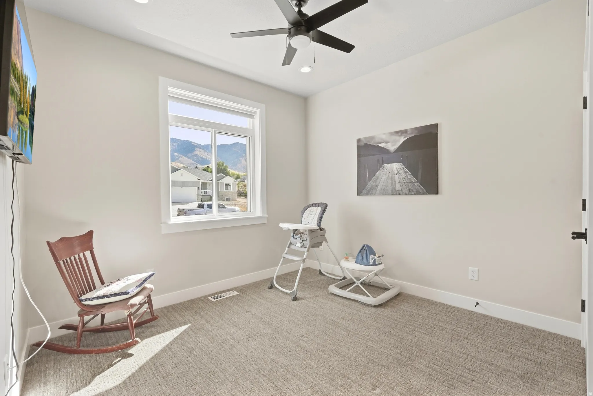 Recessed lighting, ceiling fan, carpeted flooring, window with mountain backdrop, and white trim