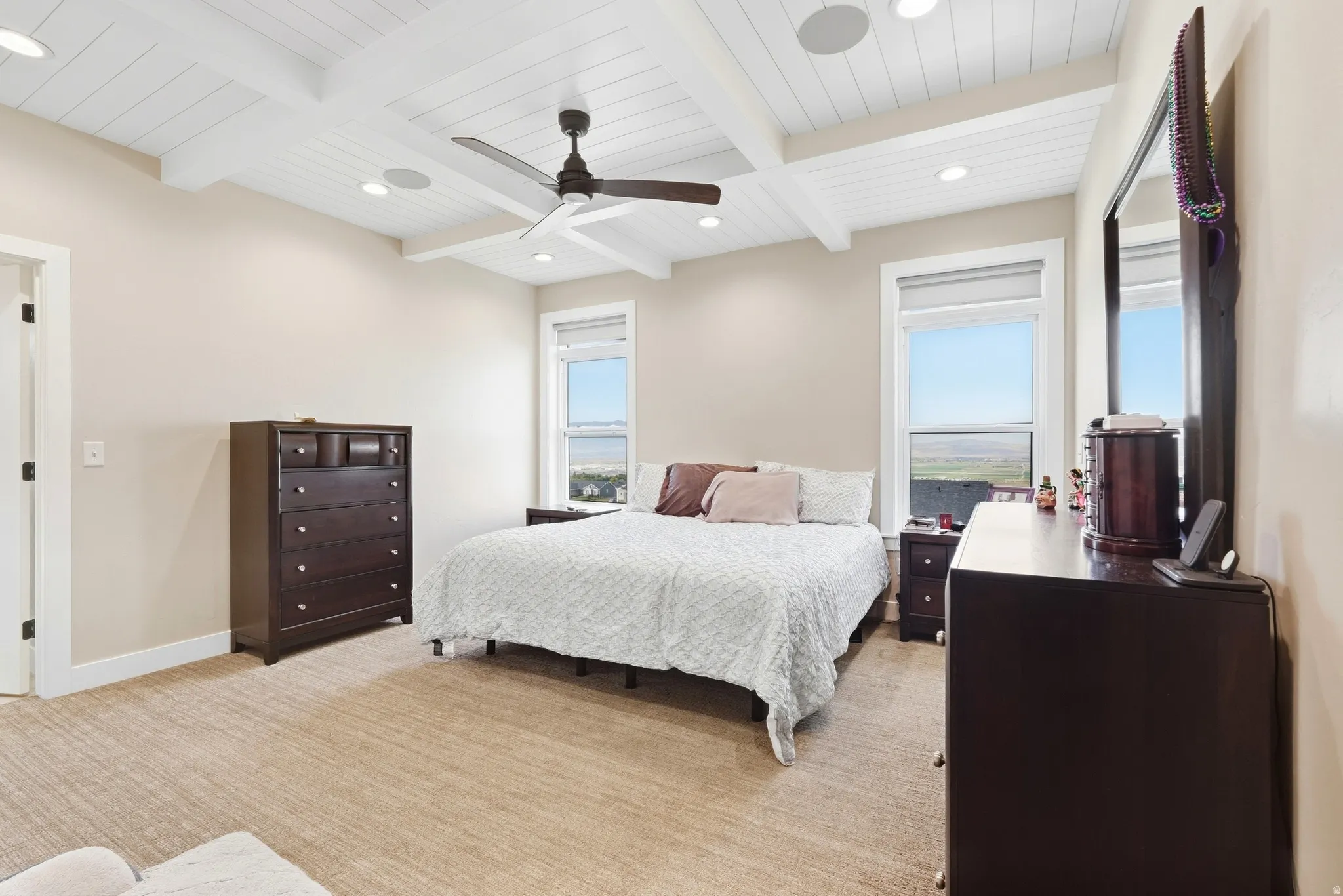 Tray ceiling with white wood paneling and exposed beams