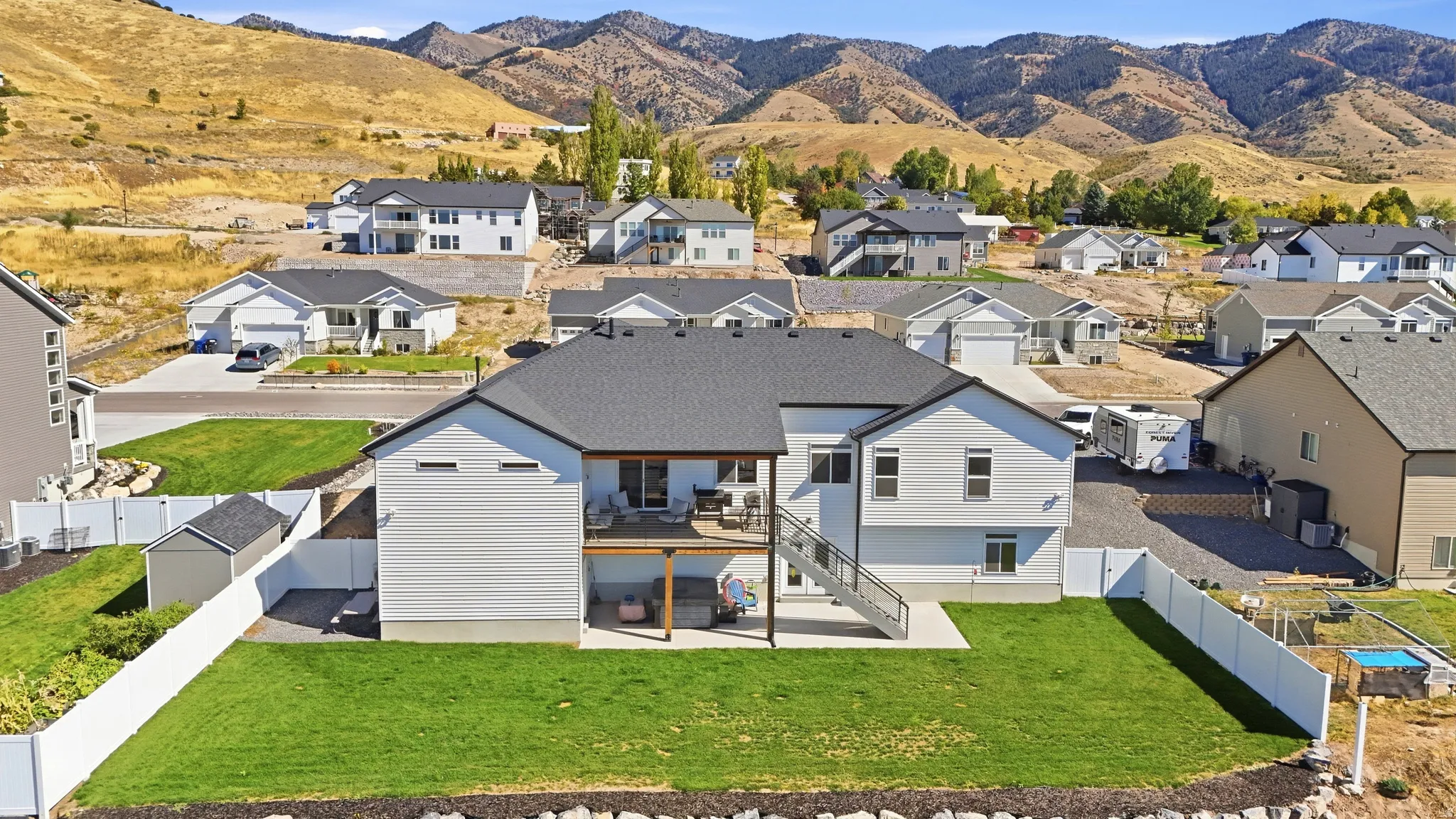 Exterior with white siding, second-story balcony, covered patio, and fenced backyard