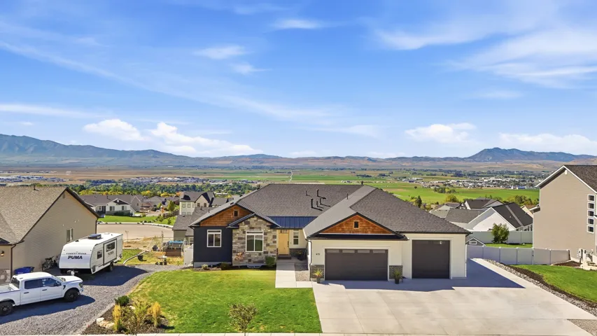 Contemporary exterior with stone and wood accents, a two-car garage, and a concrete driveway