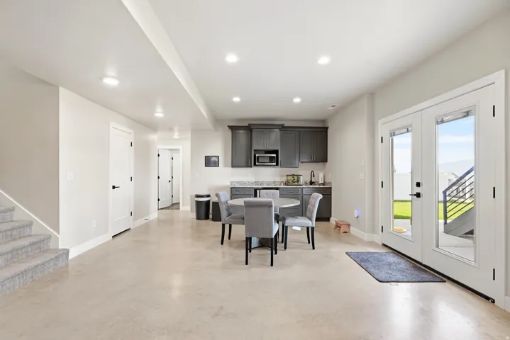 Spacious open concept living area with light-toned flooring and recessed lighting