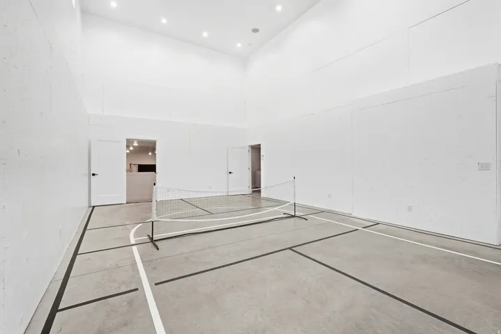 Indoor court with marked concrete flooring, high ceilings, and recessed lighting
