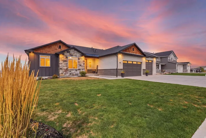 Exterior featuring a stone and siding facade, wood shake accents, and a dual garage with carriage-style doors