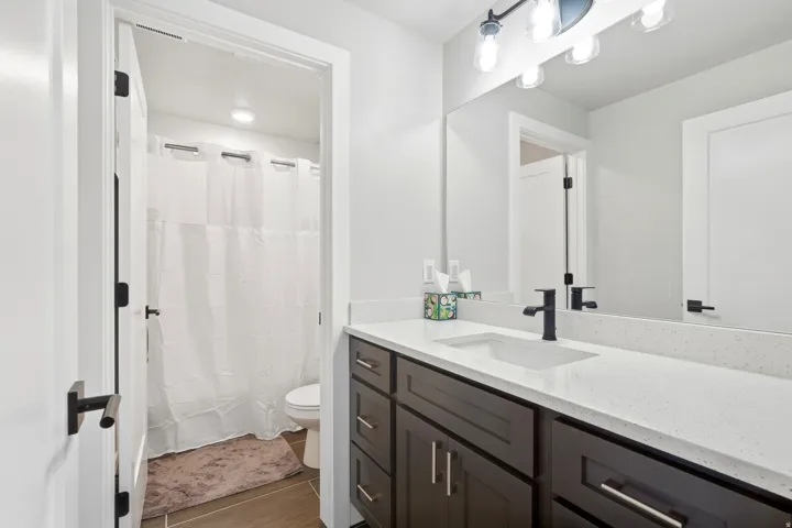 Dark wood-finish vanity with a white solid surface countertop and undermount sink