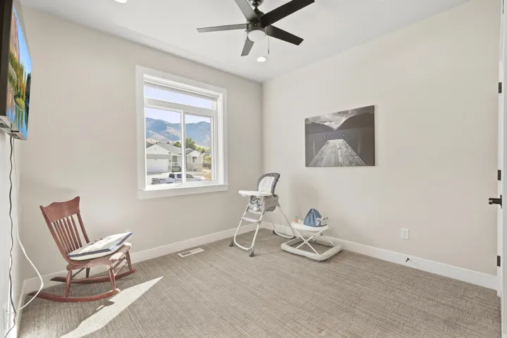 Recessed lighting, ceiling fan, carpeted flooring, window with mountain backdrop, and white trim