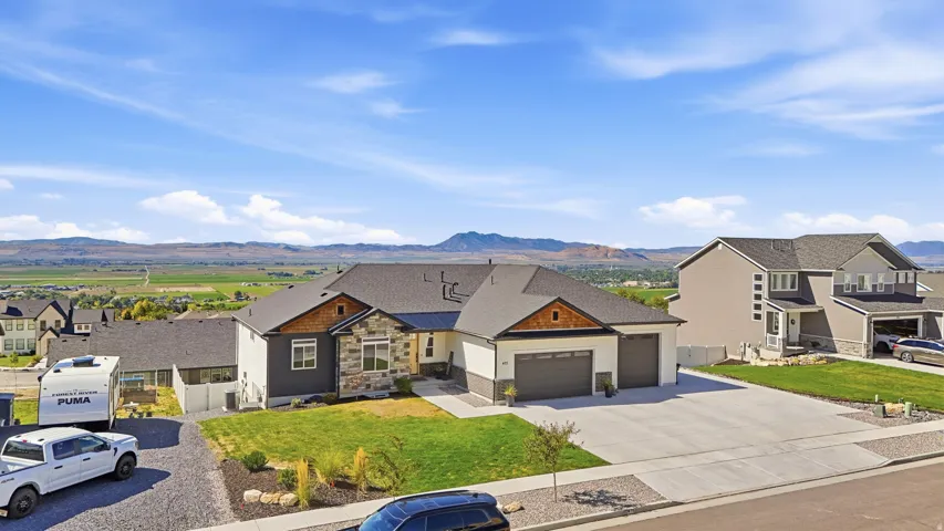 Contemporary-style exterior with stone and siding accents, prominent two-car garage, and well-maintained front lawn