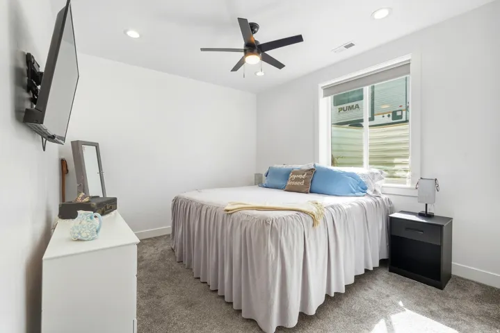 Recessed lighting, ceiling fan, wall-mounted television, and carpeted flooring