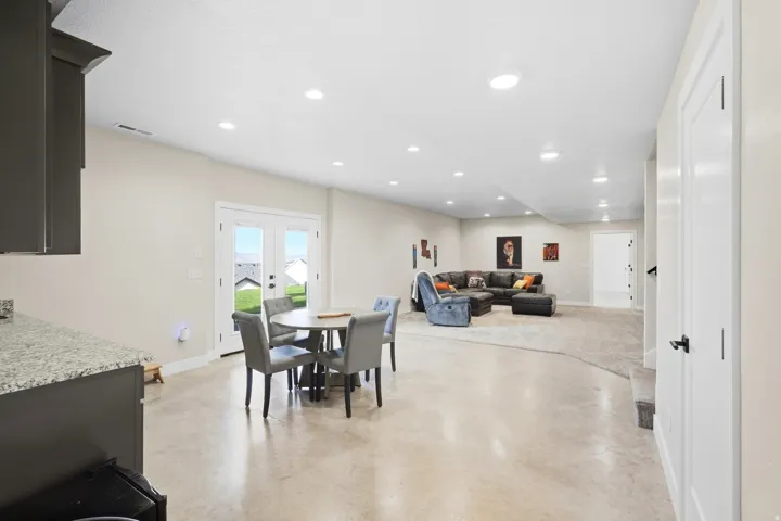 Spacious open-concept living area with recessed lighting and light-toned walls