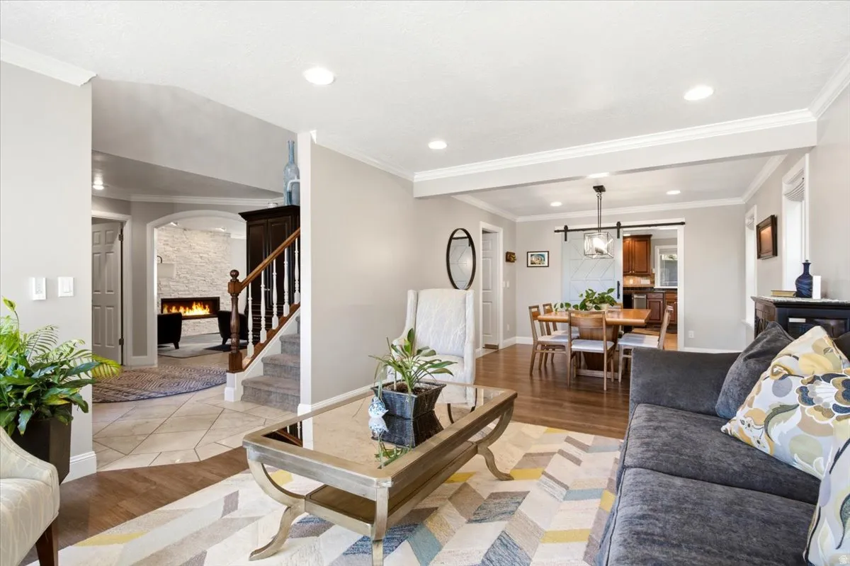Recessed lighting, crown molding, and wood-finish flooring enhance the living area