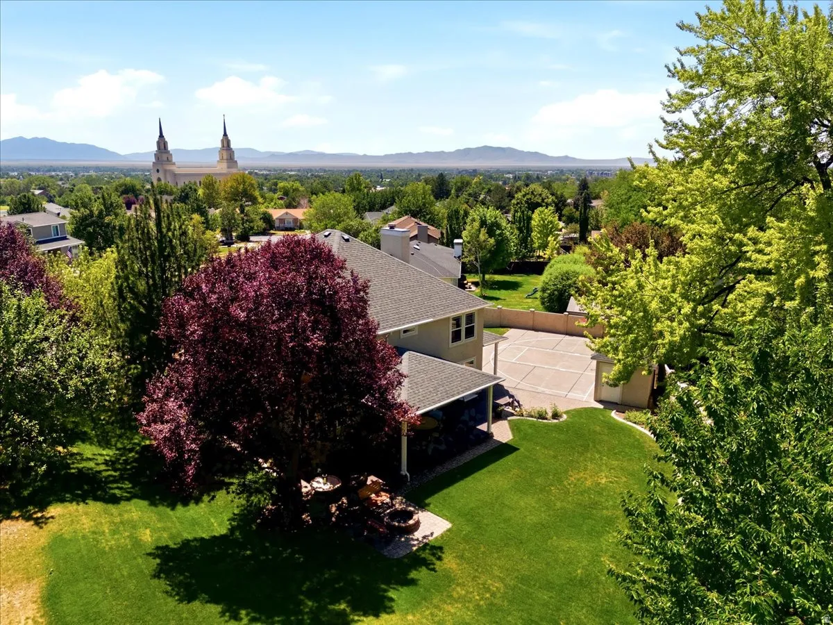 Expansive lawn with mature trees and a paved patio area