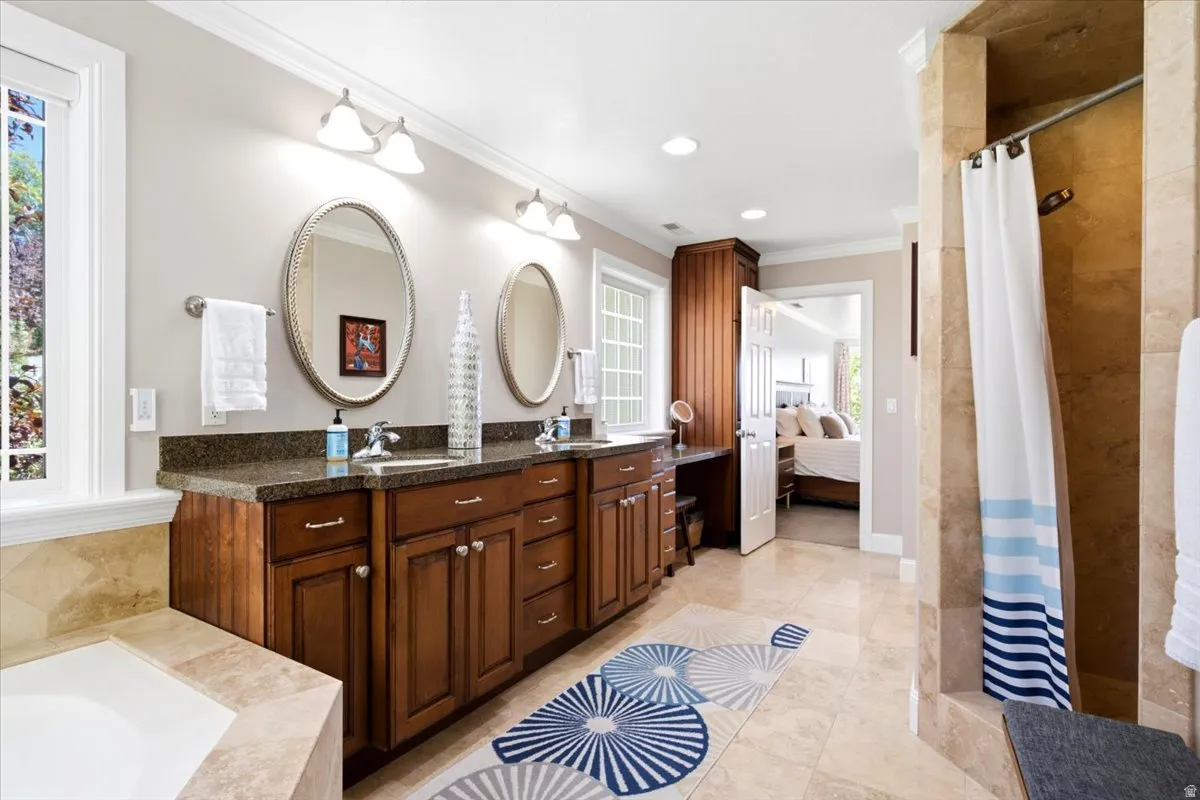 Dual vanity with integrated sinks, rich wood-finish cabinetry, and dark countertop