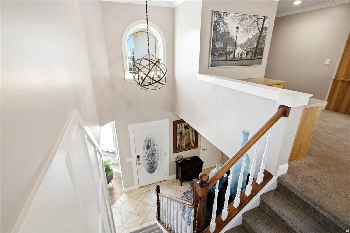 Two-story foyer with an arched window, spherical pendant light, and tiled flooring
