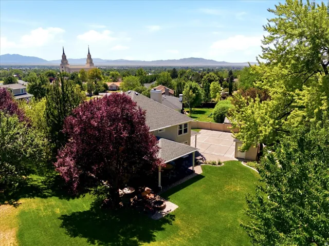 Expansive lawn with mature trees and a paved patio area