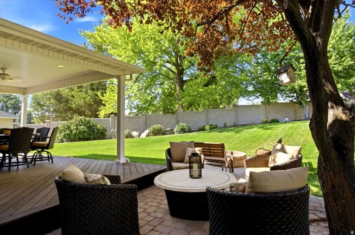 Covered deck with a ceiling fan, plank-style decking, and recessed lighting