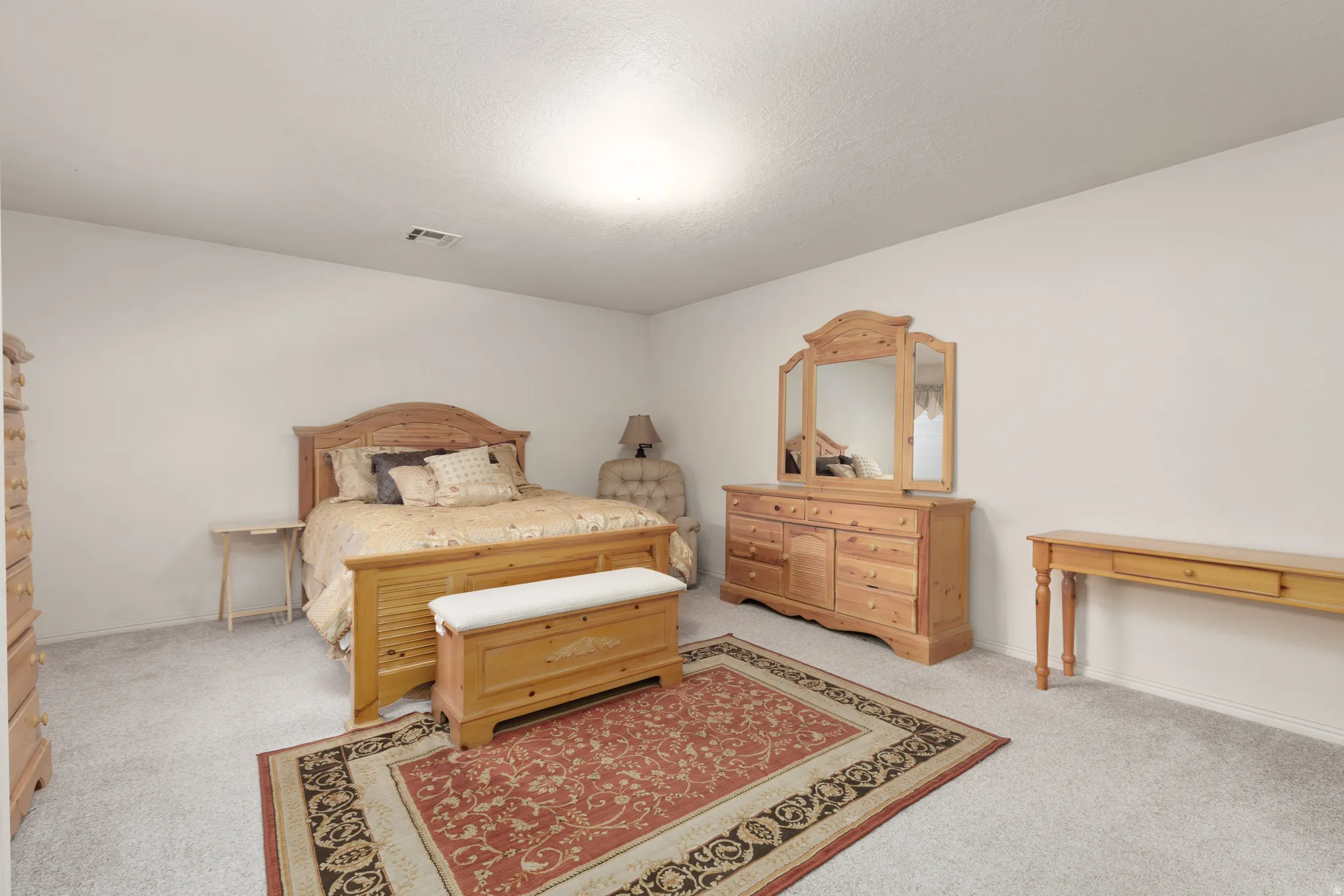 Neutral wall tones, ceiling-mounted light fixture, and textured carpeting
