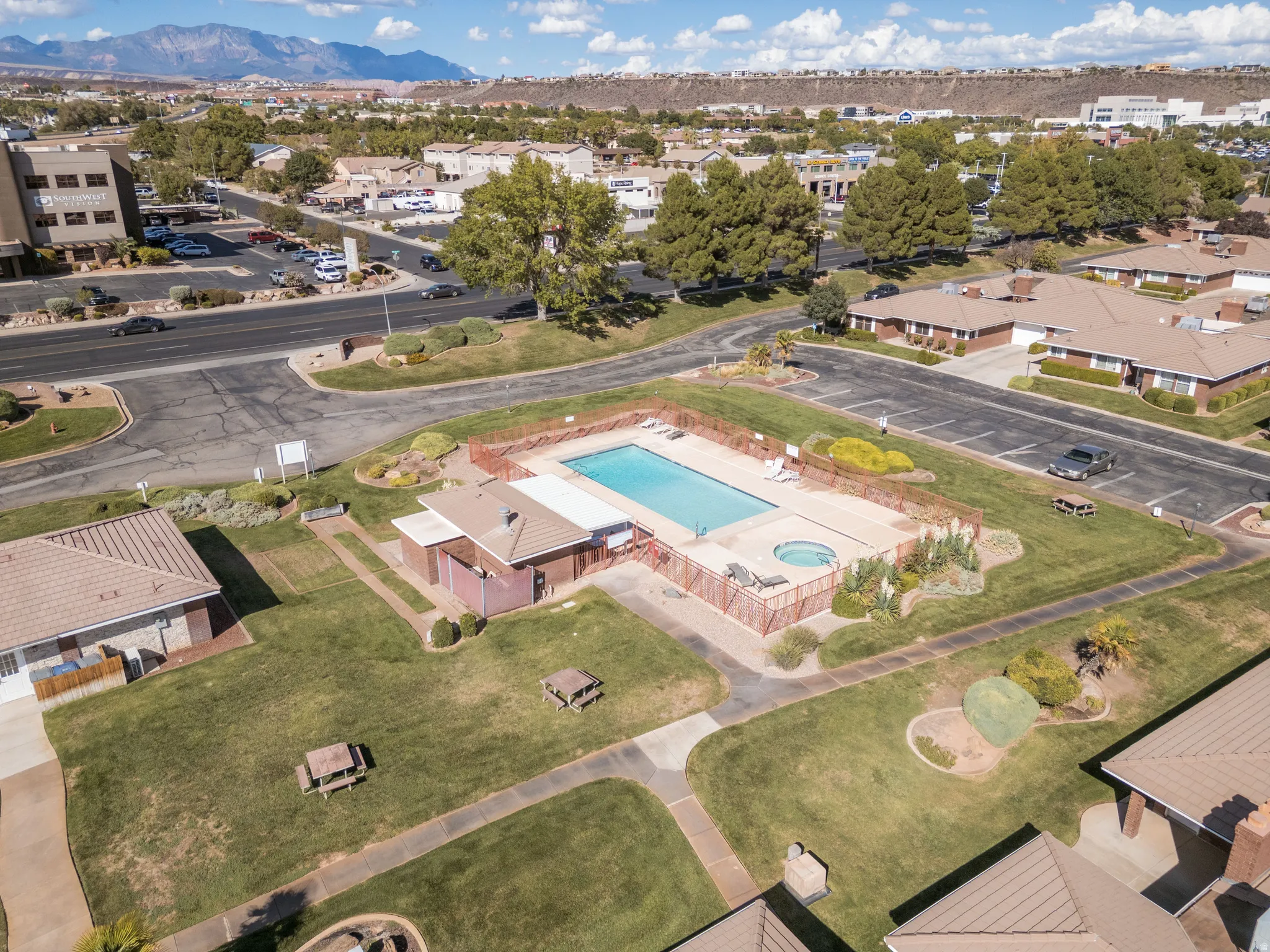 Outdoor swimming pool with integrated spa and surrounding paved deck