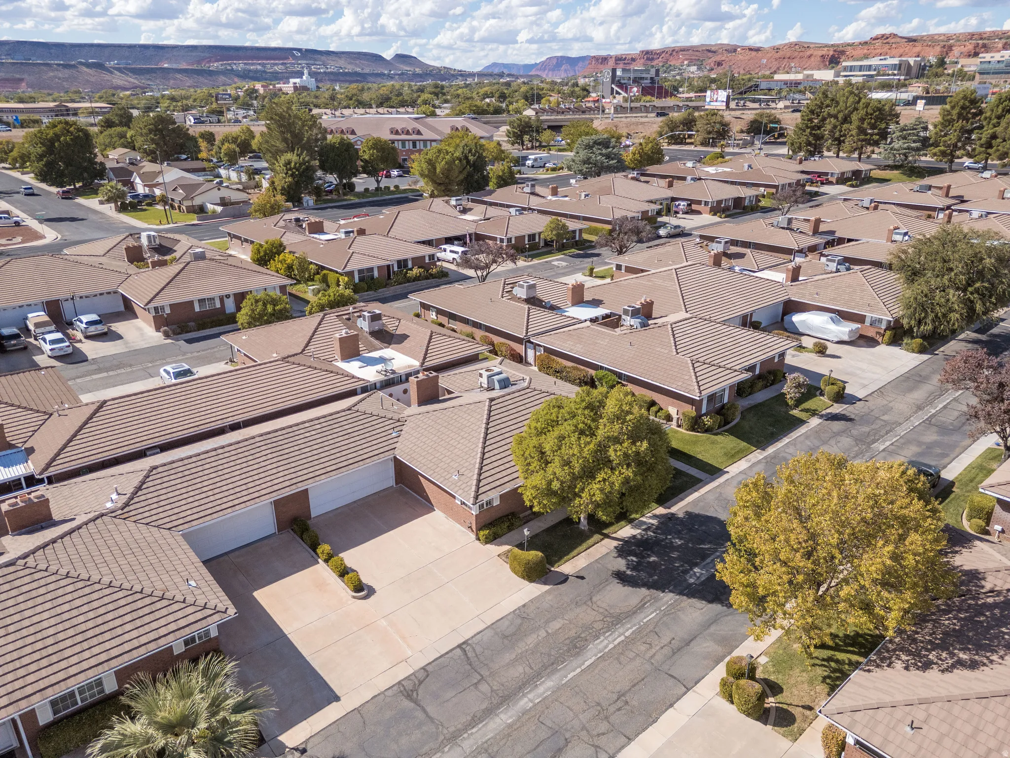 Residential neighborhood featuring tile roofs, mature trees, and landscaped grounds
