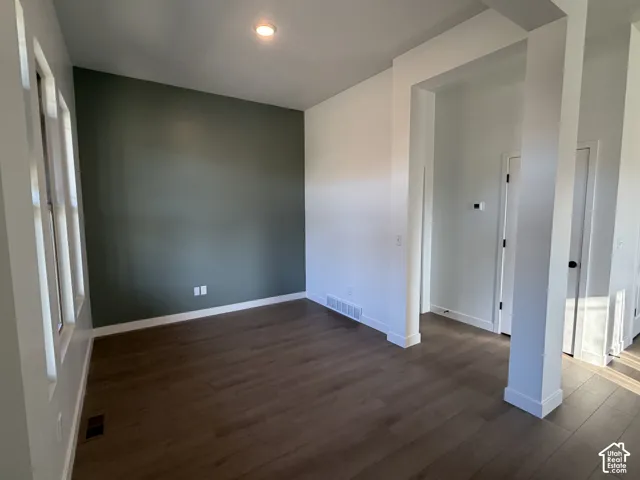 Recessed lighting, wood-finish flooring, a feature wall, and white trim