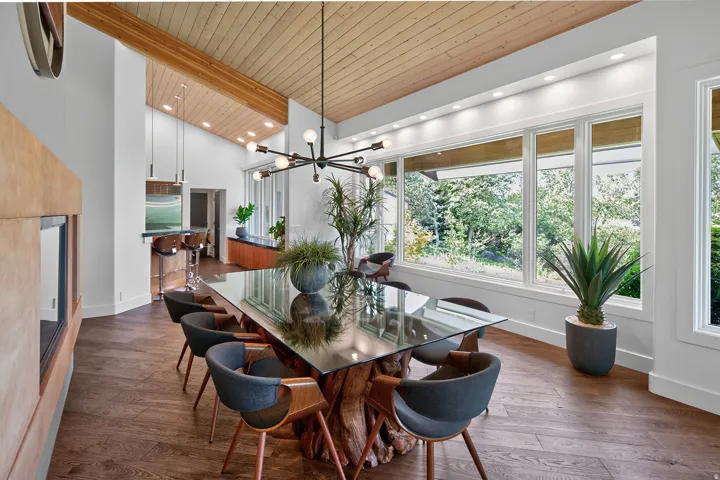Vaulted wood-paneled ceiling, recessed lighting, expansive picture windows, wood-finish flooring, and a built-in fireplace