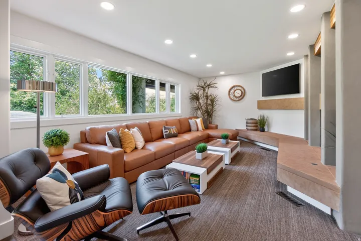 Recessed lighting, extensive window banks, built-in entertainment shelving, and textured carpeting