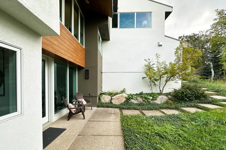 Modern exterior featuring white stucco, wood paneling accents, and large windows