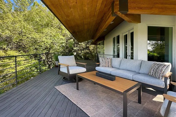 Expansive deck featuring dark composite decking and a black metal railing