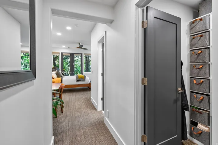 Hallway featuring carpet flooring, recessed lighting, and a dark-paneled door
