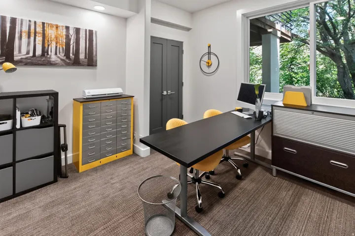 Large window with exterior foliage, dark-paneled door, recessed lighting, and textured carpeting