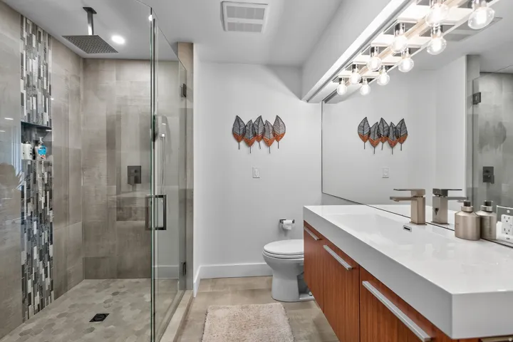 Contemporary bathroom featuring a floating wood-finish vanity with an integrated rectangular sink
