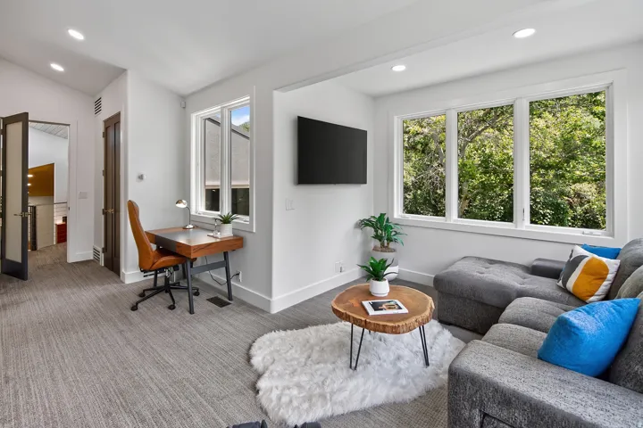 Recessed lighting, large windows, and light-toned walls create an airy ambiance