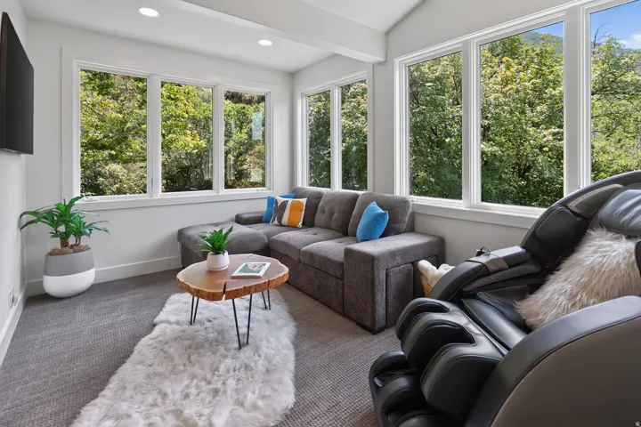 Recessed lighting, sloped ceiling, multiple large windows, and carpeted flooring