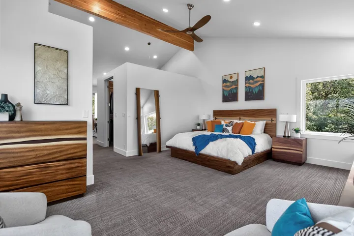 Vaulted ceiling with exposed wood beam, recessed lighting, ceiling fan, and large window