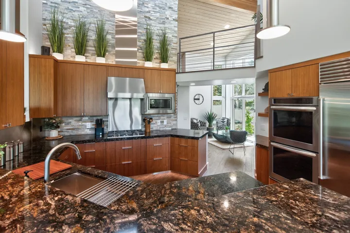 Granite countertops, wood-finish cabinetry, stainless steel appliances, and a tile backsplash