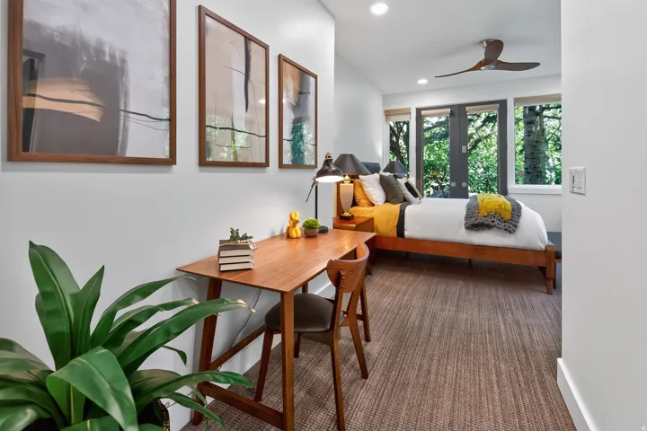 Hardwood bed frame, ceiling fan, recessed lighting, and wall-mounted art