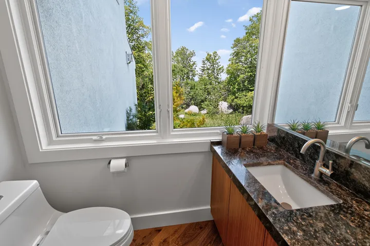 Modern vanity with a dark patterned countertop, integrated sink, and wood-finish cabinetry