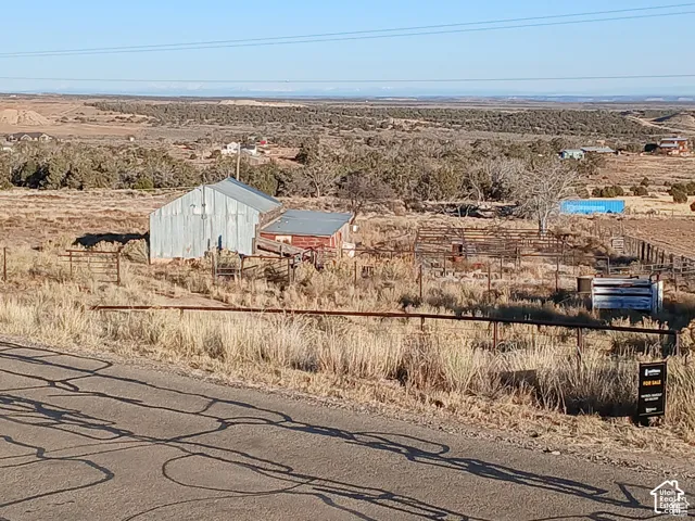 Existing structures include a large metal-sided outbuilding and a smaller red-sided structure