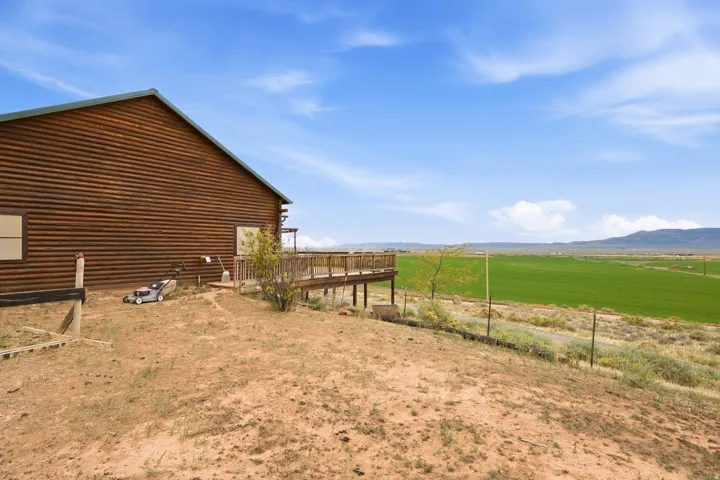 Wood-sided exterior with an expansive outdoor deck, and distant mountains