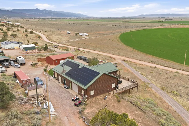 Wood-sided residence with solar panels and a green metal roof