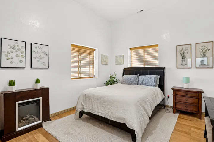Hardwood flooring, two windows with wood blinds, and a built-in fireplace
