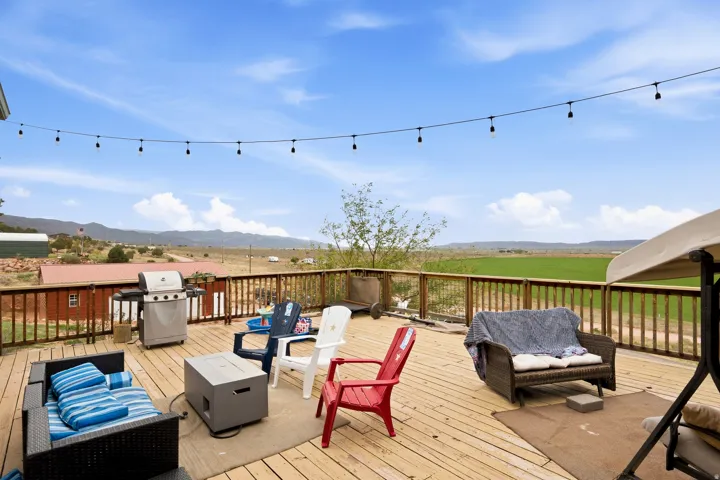Expansive wood deck with a perimeter railing and string lighting