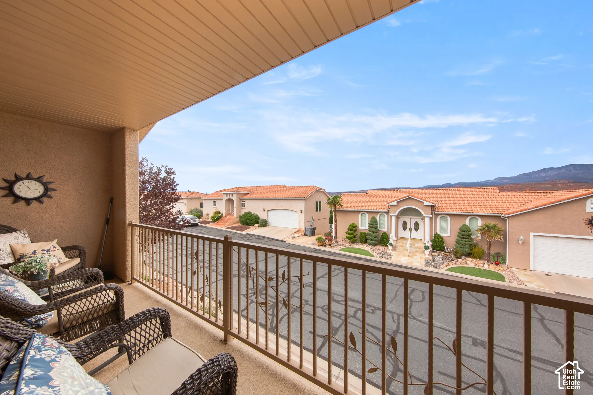 Balcony with a textured wall finish, slatted ceiling, and decorative metal railing