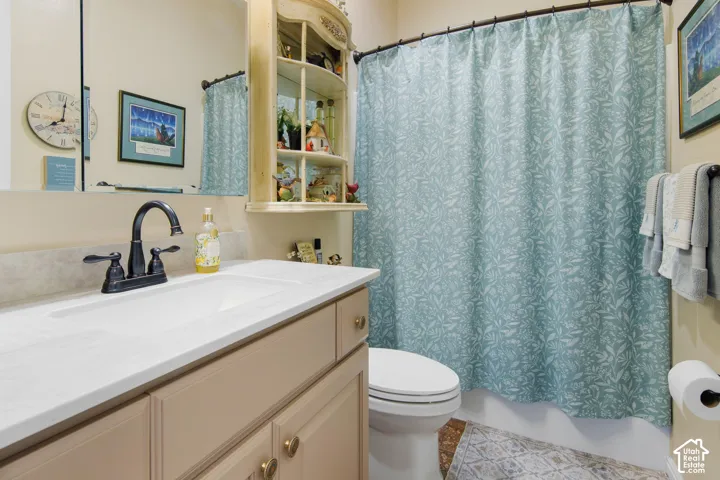 Bathroom vanity with a white countertop and integrated sink, bronze-finish faucet, and built-in storage shelving