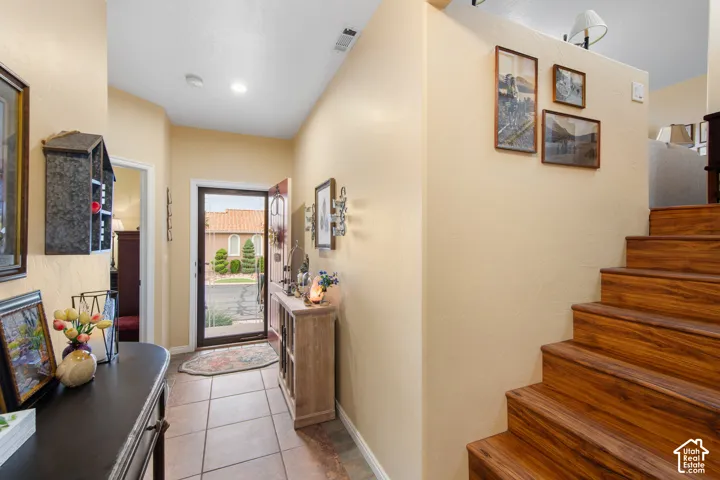 Entryway featuring tile flooring, a wood-finish staircase, and recessed lighting