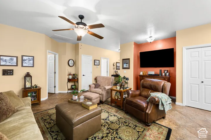 Recessed ceiling with a centrally mounted ceiling fan, neutral wall tones, and tiled flooring