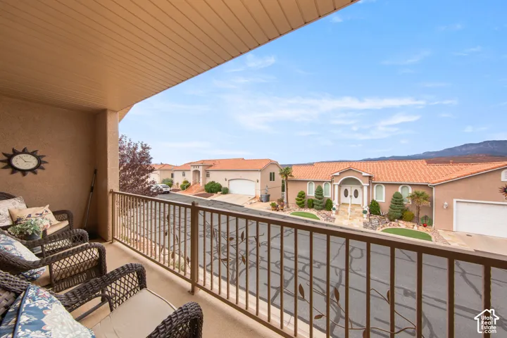Balcony with a textured wall finish, slatted ceiling, and decorative metal railing