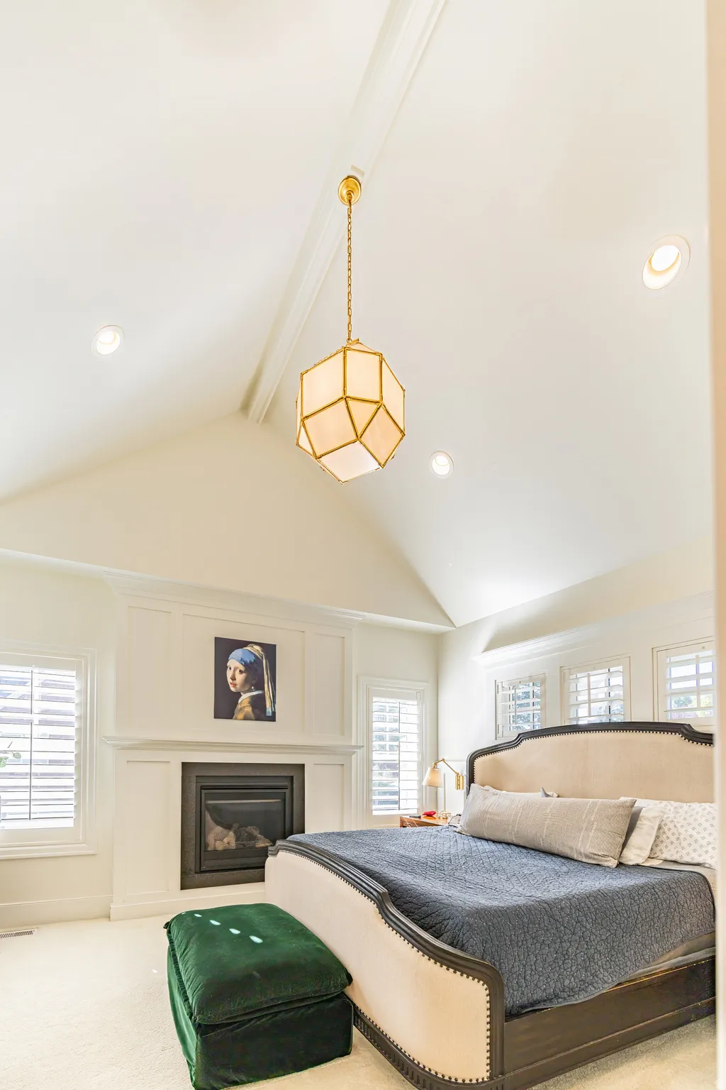 Vaulted ceiling with a geometric pendant light, recessed lighting, and a built-in fireplace with a mantel