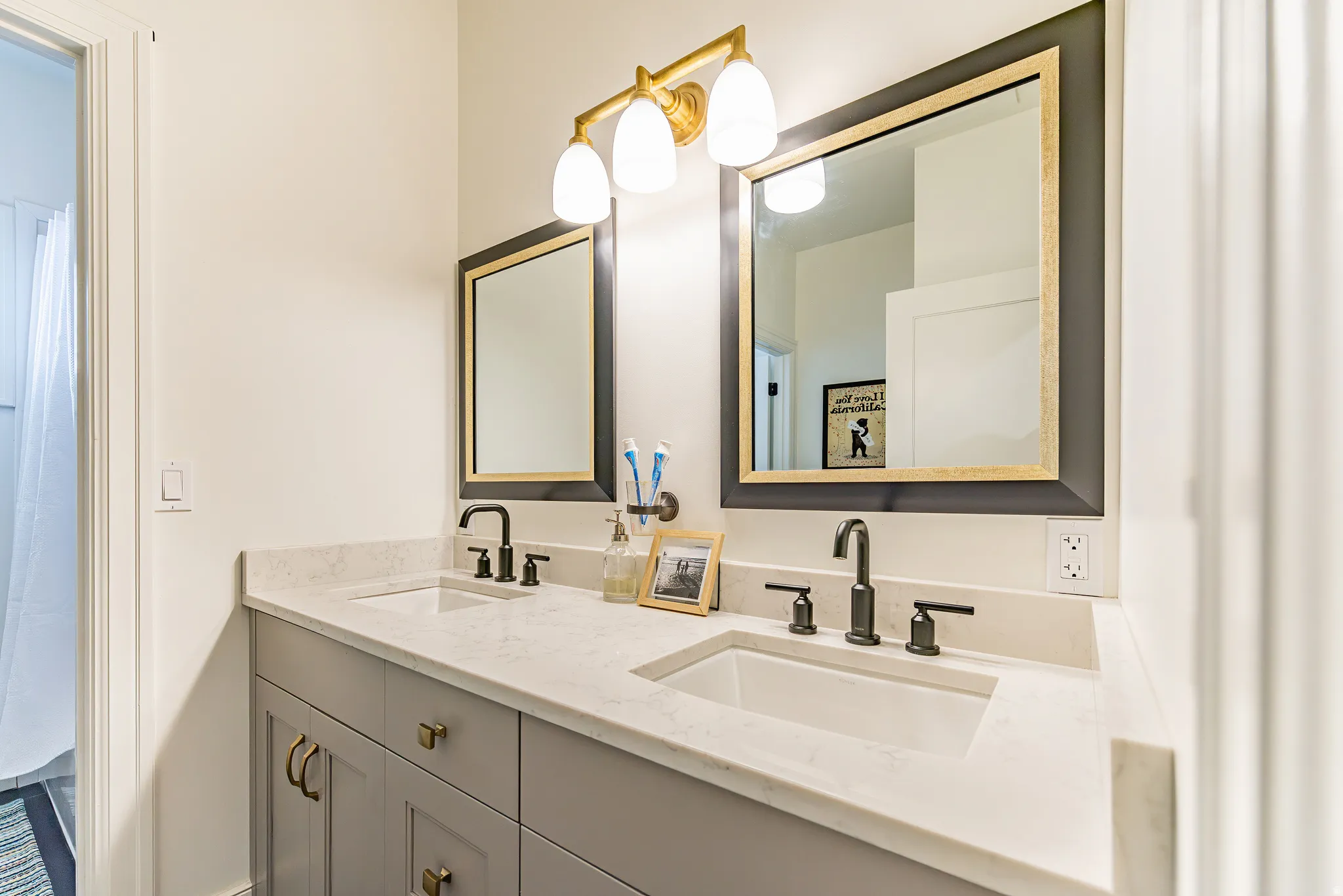 Double vanity with light gray cabinetry, integrated sinks, and light-toned countertops