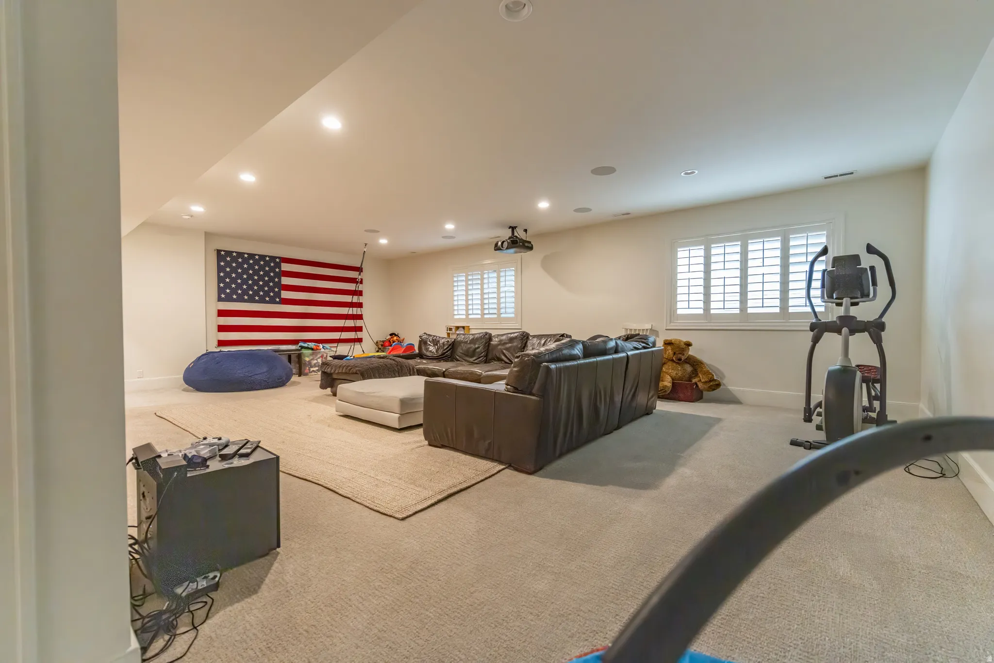 Recessed lighting, light-toned carpeting, and plantation shutters