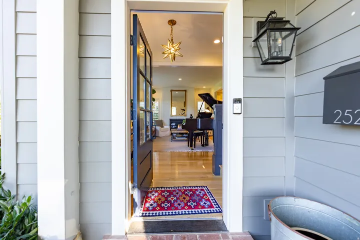 Panel siding exterior with a prominent wall lantern, house number 252, and a glass-paneled entry door